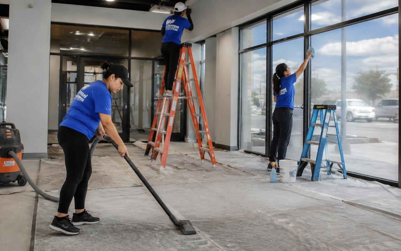 Post-construction crew removing drywall dust and cleaning new storefront glass — post-construction cleaning in Apollo Beach, FL by Florida Commercial Cleaning